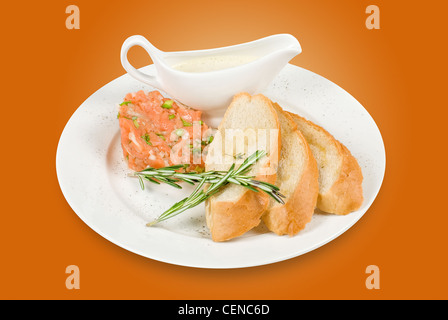 Tar-tar à partir de saumons poisson avec l'oignon vert. Servi avec sauce au miel et de pain blanc grillé. Banque D'Images