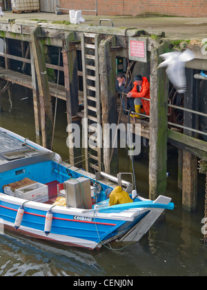 Deux avec un pêcheur coble pêche tout juste d'arriver à Whitby en attente de décharger leurs prises Banque D'Images
