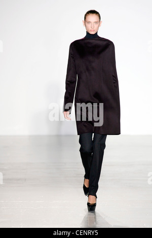 Jil Sander Prêt-à-Porter Automne Hiver Milan Model wearing black pantalon skinny leg, manteau noir, black wedge chaussures unique Banque D'Images