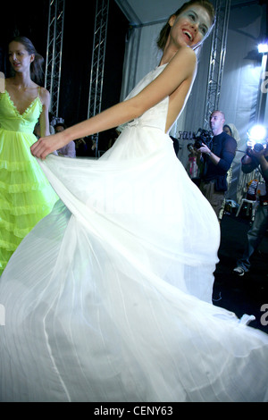 Giambattista Valli Backstage Paris Printemps Été RTW Brunette model tournant sur un livre blanc en dentelle robe de soirée dos nu Banque D'Images