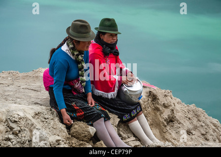 Les deux femmes indiennes équatoriennes arrêt guides pour une pause déjeuner avec vue sur le cratère Quilotoa Quilotoa, Equateur,. Banque D'Images