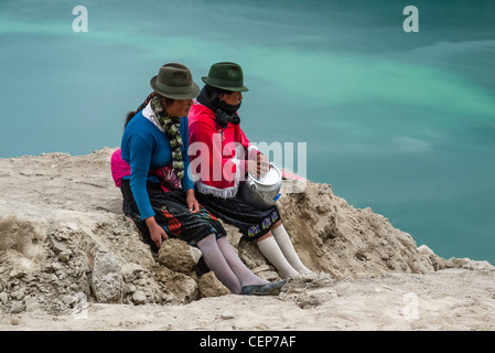 Les deux femmes indiennes équatoriennes arrêt guides pour une pause déjeuner avec vue sur le cratère Quilotoa Quilotoa, Equateur,. Banque D'Images