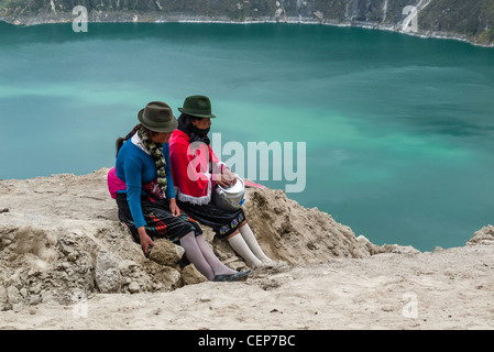 Les deux femmes indiennes équatoriennes arrêt guides pour une pause déjeuner avec vue sur le cratère Quilotoa Quilotoa, Equateur,. Banque D'Images