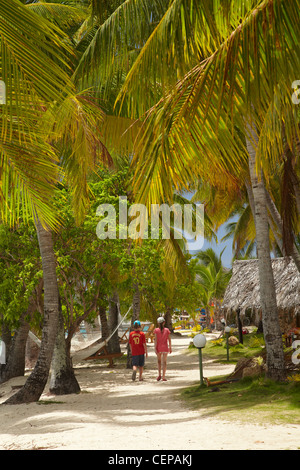 Les enfants marcher le long chemin bordé de palmiers, Plantation Island Resort, Malolo Lailai Island, Yasawa Islands, Fidji, Pacifique Sud Banque D'Images