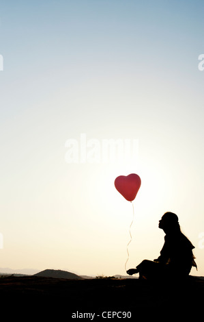 Indian woman holding a balloon. Silhouette Banque D'Images