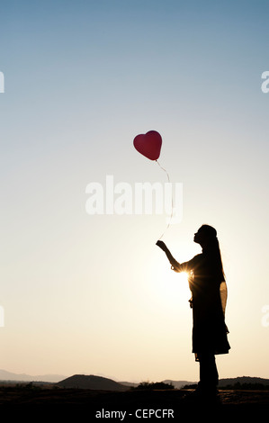 Indian woman holding a balloon. Silhouette Banque D'Images