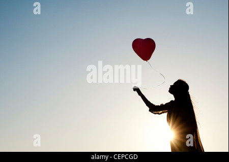 Indian woman holding a balloon. Silhouette Banque D'Images