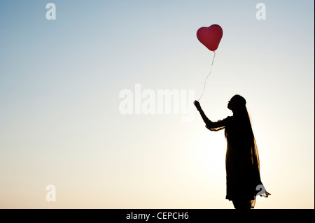 Indian woman holding a balloon. Silhouette Banque D'Images