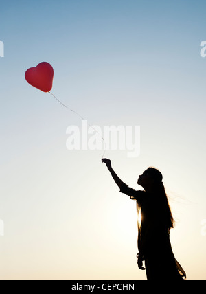 Indian woman holding a balloon. Silhouette Banque D'Images