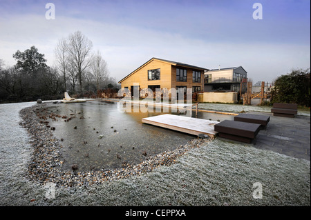 Une piscine naturelle qui n'a plus de glace en hiver à une auto construire maisons clad home UK Banque D'Images