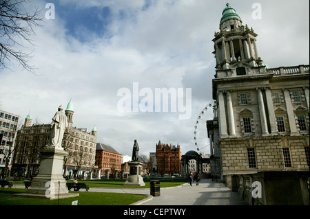 Des statues à l'avant de Belfast City Hall avec la Belfast roue dans l'arrière-plan. Banque D'Images