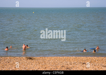 La natation de personnes dans la mer à Whitstable. Banque D'Images