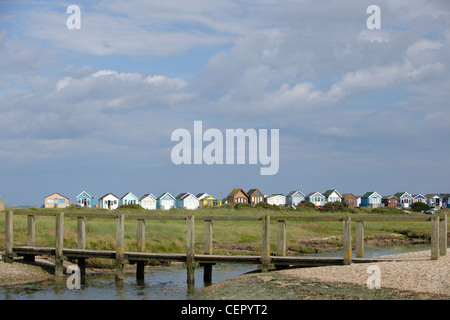 Pied en bois d'un pont sur un ruisseau à Mudeford, deux kilomètres de Christchurch, avec cabines de plage sur le front de mer de l'arrière-plan. Banque D'Images