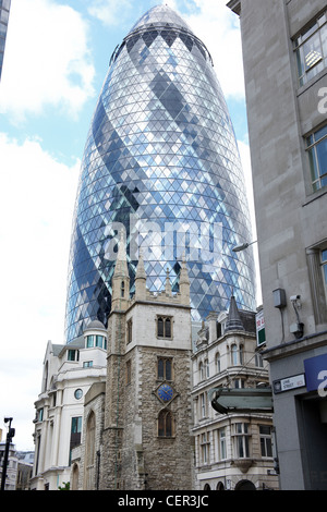 Le Gherkin building s'élevant au-dessus d'une vieille église à Londres. Banque D'Images