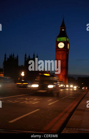 Big Ben de nuit avec un taxi passant sur le pont de Westminster. Banque D'Images