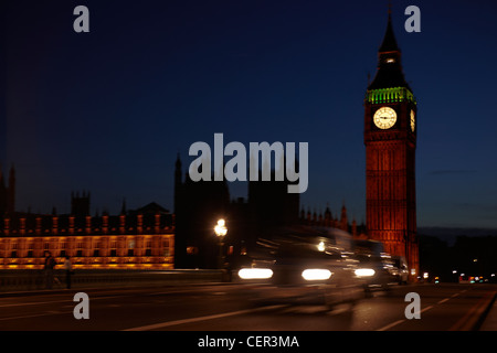 Big Ben de nuit avec un taxi passant sur le pont de Westminster. Banque D'Images