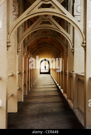 Le dirigeant d'une figure dans la distance de marcher sous les arcades de la passerelle piétonne sur le pont de haut niveau. Banque D'Images