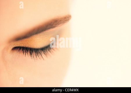 Close up of female oeil fermé avec sourcil au crayon, de l'or l'ombre à paupières et le mascara noir, prises d'en haut Banque D'Images