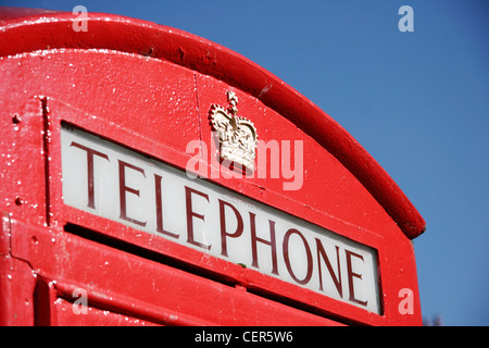 Détail d'un téléphone rouge traditionnelle box set contre un ciel bleu à Londres. Banque D'Images