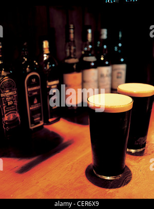 Deux pintes de Guinness sur un bar. Banque D'Images