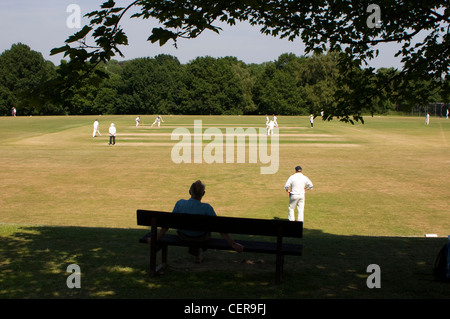 Match de Cricket se joue sur un village vert. Banque D'Images