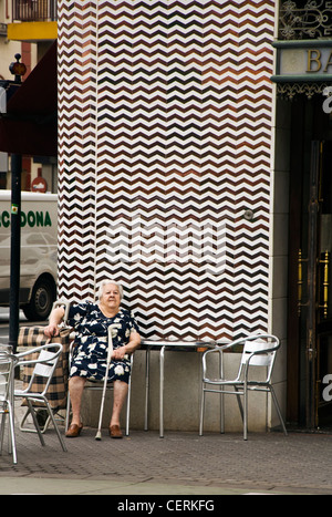 Personnes âgées senior woman se trouve à l'extérieur d'un café avec son panier Banque D'Images