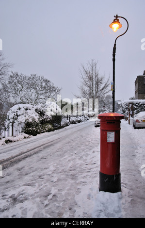 Un Londres post box et l'éclairage public entouré par la neige. Banque D'Images