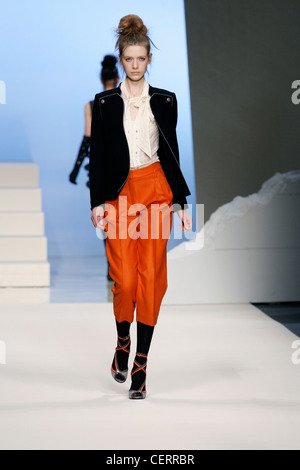 Sportmax Milan Prêt à Porter Automne Hiver Model wearing orange pantalon 3/4, chemisier blanc et noir cravate militaire détail Banque D'Images
