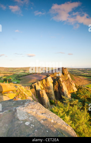 Les blattes, un affleurement de roches sculptées pierre meulière, éclairé par la lumière chaude soirée dans le parc national de Peak District. Banque D'Images