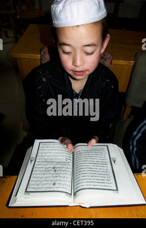 Un jeune musulman hui étudier le Coran. Banque D'Images