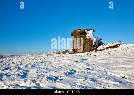 Neige sur et autour de la mère, une grande formation de roche pierre meulière dans le parc national de Peak District. Banque D'Images