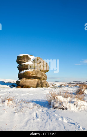 La pierre de l'aigle sur le bord Buxton après une forte chute de neige de l'hiver dans le parc national de Peak District. Banque D'Images