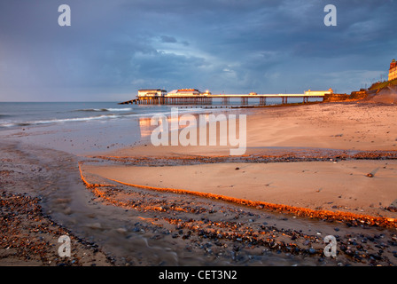 La lumière sur la jetée de Cromer orageux peu avant le coucher du soleil sur la côte nord du comté de Norfolk. Banque D'Images