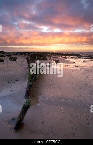 Coucher de soleil sur l'épave reste de l'hôtel Sheraton sur la plage à Old Hunstanton sur la côte nord du comté de Norfolk. Banque D'Images