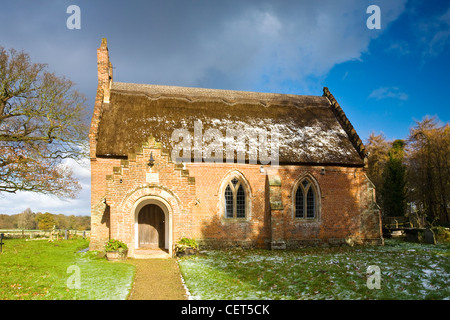 La lumière de la neige sur le toit de chaume de l'église du 17ème siècle, Saint Pierre, Hoveton. Banque D'Images