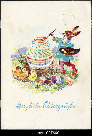 Imprimer carte postale de Pâques en RDA montre un lapin peint les oeufs et les poussins, vers 1965. Texte allemand : Joyeuses Pâques ! Banque D'Images