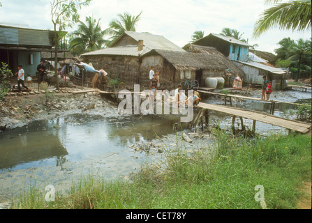 Village, à côté de la rivière à marée basse pendant la guerre du Vietnam. Enfants jouant Banque D'Images