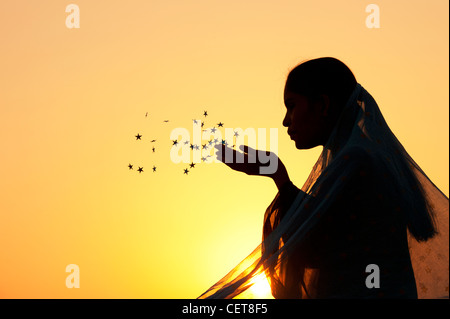 Indian girl portant un châle star stars de soufflage dans l'air. Silhouette Banque D'Images