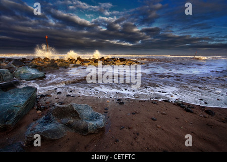 Vagues se brisant sur les rochers à la station balnéaire de Withernsea. Banque D'Images