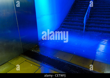 Passage sous la nuit éclairé par des néons bleus sous la pluie Banque D'Images