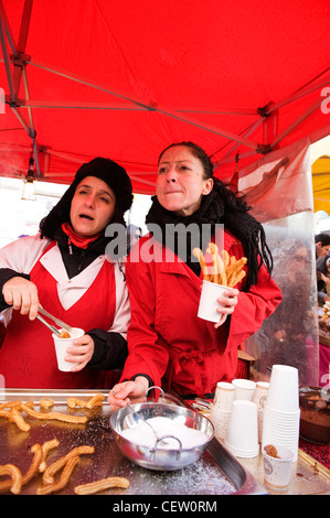 La rue Portobello Road Market Londres espagnol donut donut Churros stall deux jolies filles servant de chocolat sucre Banque D'Images