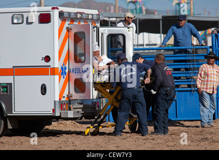 Aider les travailleurs EMS homme blessé dans la monte de taureau à la concurrence All-Indian Rodeo Banque D'Images