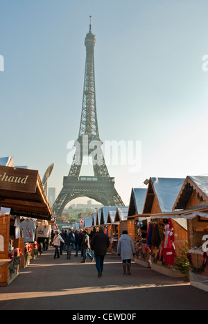 Paris, France. Achats de Noël dans un marché de chalets au-dessous de la Tour Eiffel, Banque D'Images