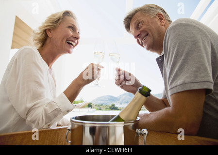 Mature couple toasting with champagne Banque D'Images