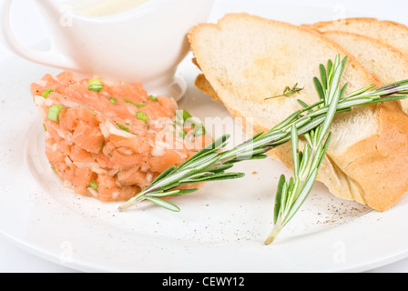Tar-tar à partir de saumons poisson avec l'oignon vert. Servi avec sauce au miel et de pain blanc grillé. Banque D'Images