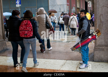 Immigrants bengali qui vend des parapluies, Milan, Italie Banque D'Images