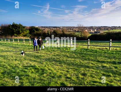 Un deux femmes marcher un petit chien à Ascot House Hill, près de Worthing Banque D'Images