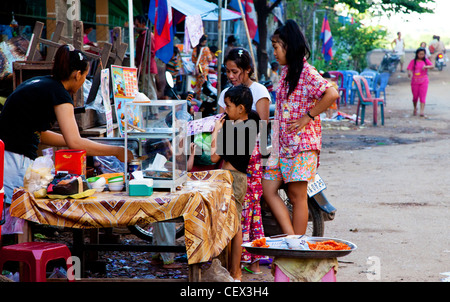 Les enfants d'acheter de la nourriture à un vendeur de rue à Kratié, Cambodge Banque D'Images