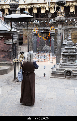 Femme mature en laissant une offrande dans un temple dans Thamel, Katmandou - Zone Bagmati, Vallée de Katmandou, Népal Banque D'Images