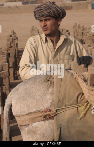 Un garçon agent travaillant dans une briqueterie près d'Islamabad, Pakistan Banque D'Images